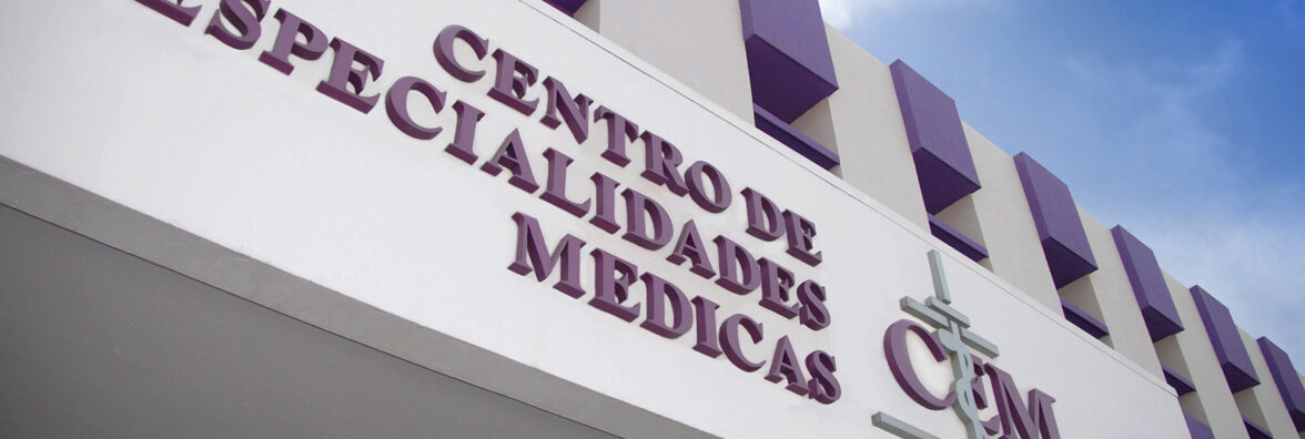 Fachada del CEM: el nombre en letras moradas sobre el muro blanco y los parasoles morados